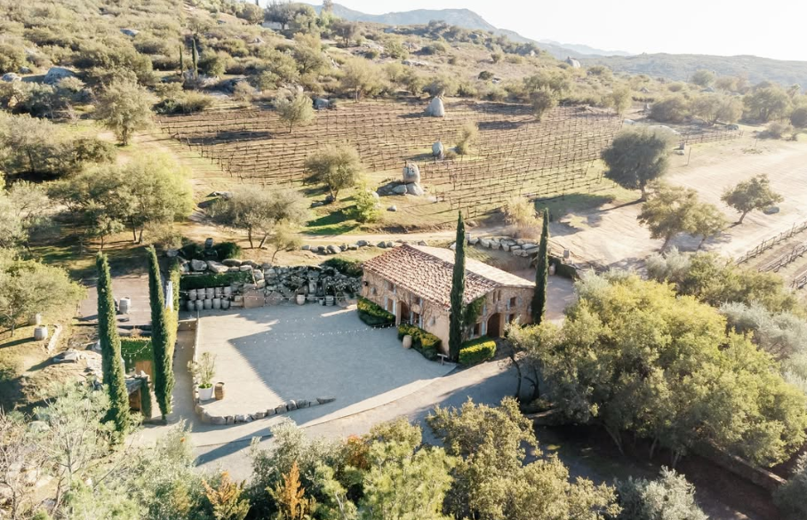 Aerial view of Milagro Winery — the stone house, cypress courtyard, and vineyards